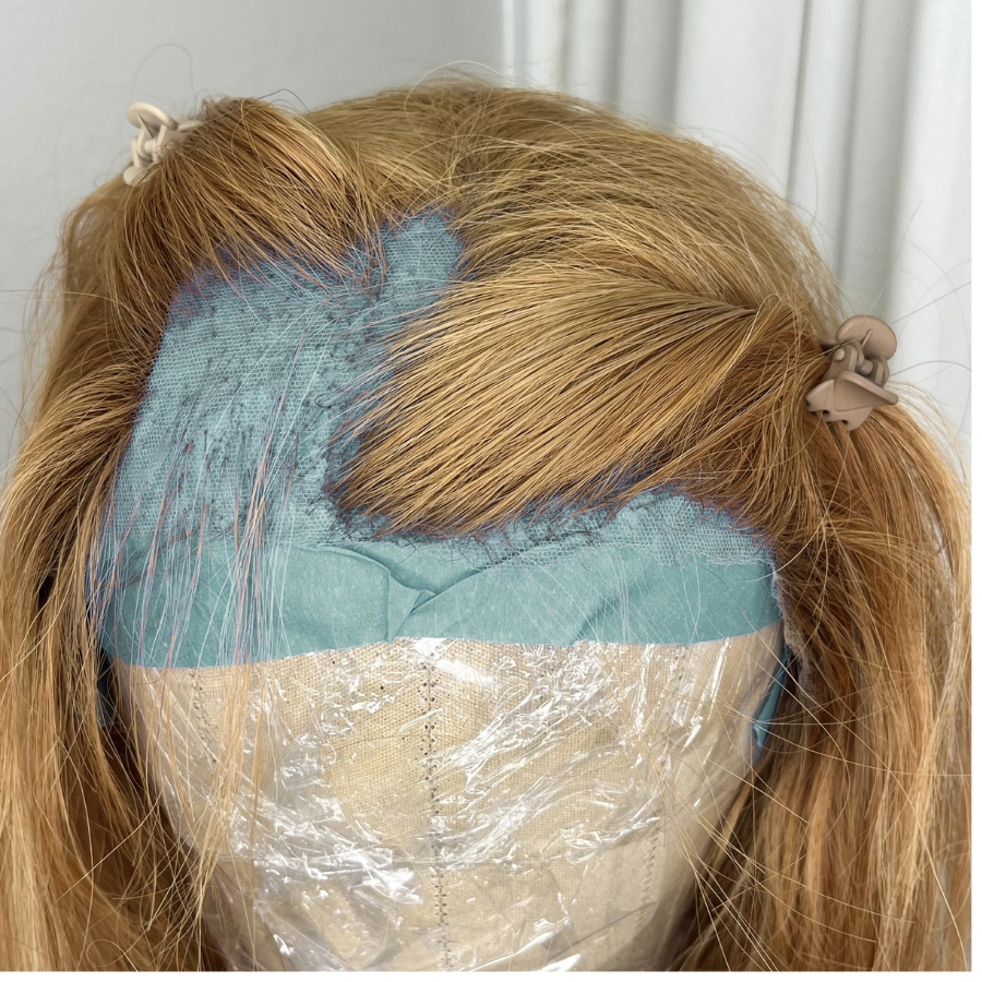 Top view of wig on canvas block with bald spot on the POV left side in temples before fill in service
