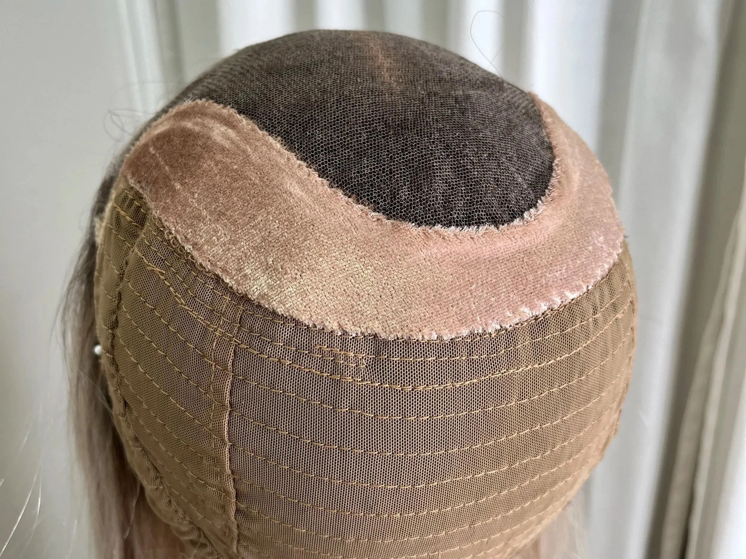 Close-up of the inside of a wig showing velvet grip material surrounding the lace top.