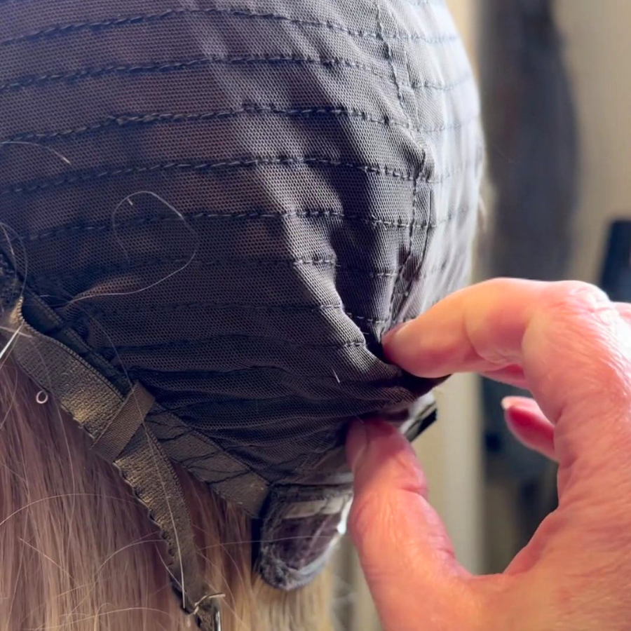 Person adjusting a horse's saddle or blanket with their hand, close-up view.