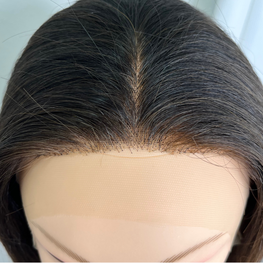 Front view of dark wig on mannequin head after fill in service is completed with dense natural looking hairline and part.