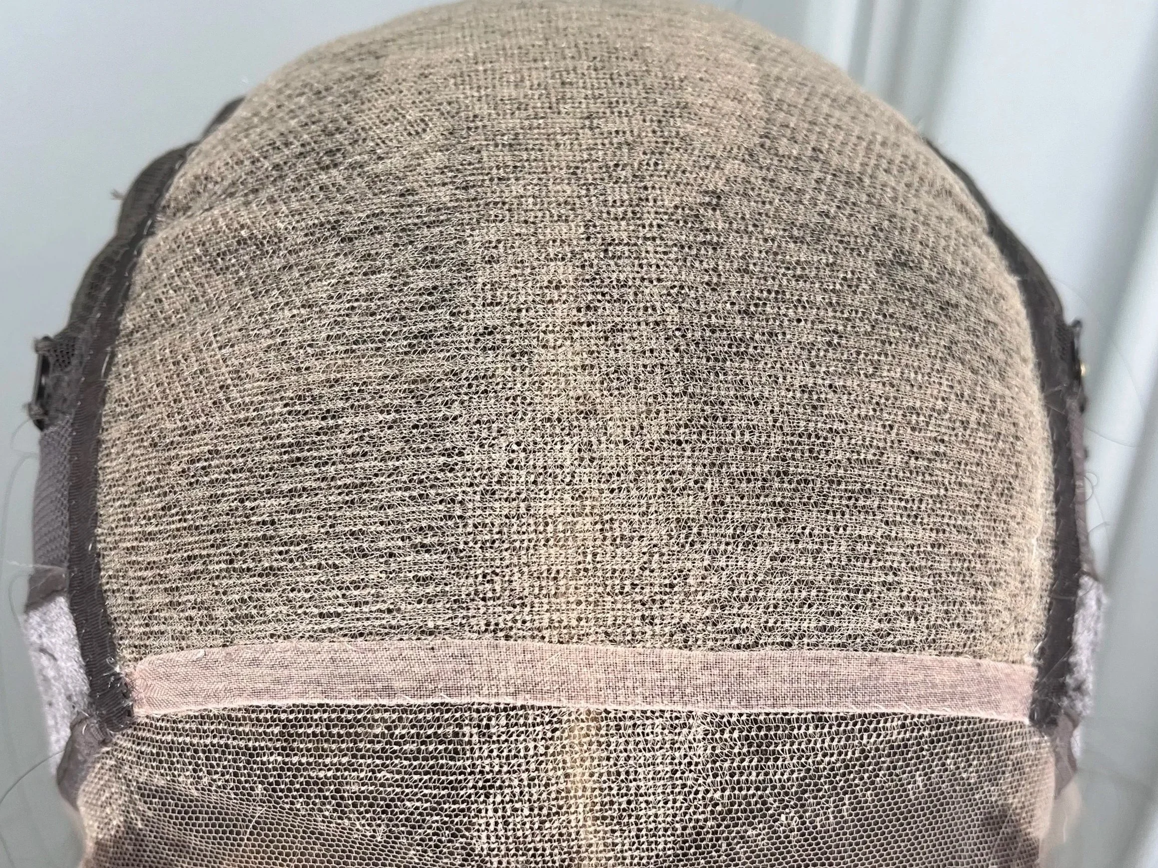 Close-up of a wig cap with mesh material, showing the scalp area for a lace front wig.