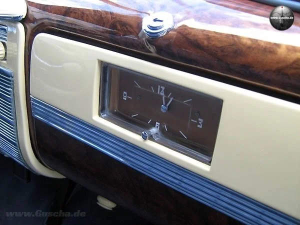 Farbaufnahme von rechts oben zeigt die braungoldene Uhr im Handschuhfach des ZIS-110