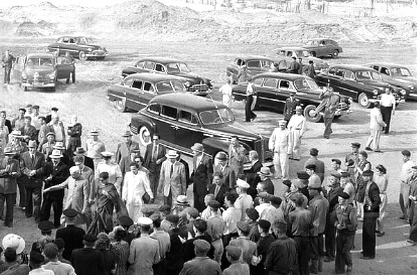 S/W-Foto mit Ansammlung von Menschen und Autos