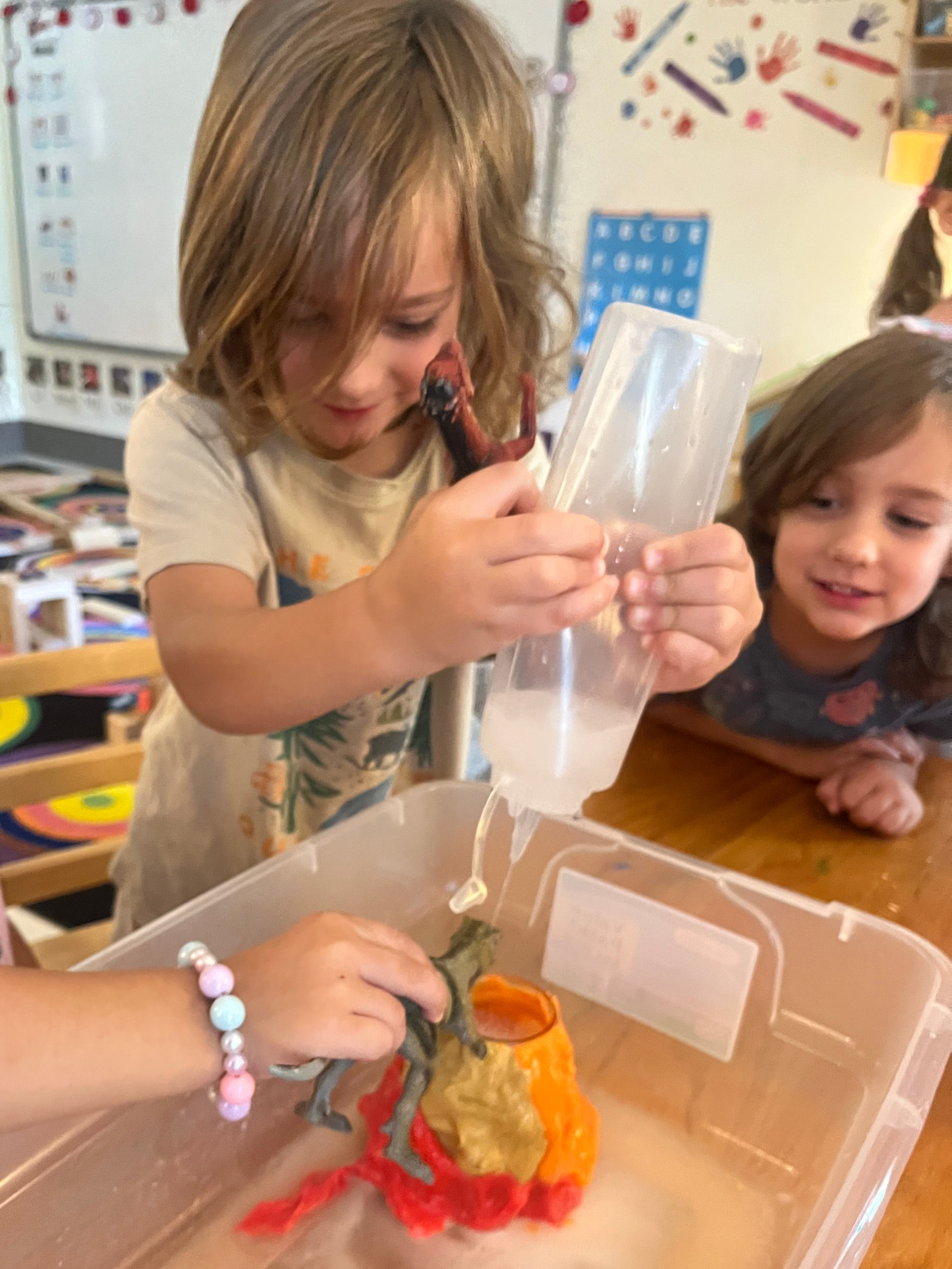 Children excitedly doing a volcano experiment with vinegar and baking soda and a toy dinosaur