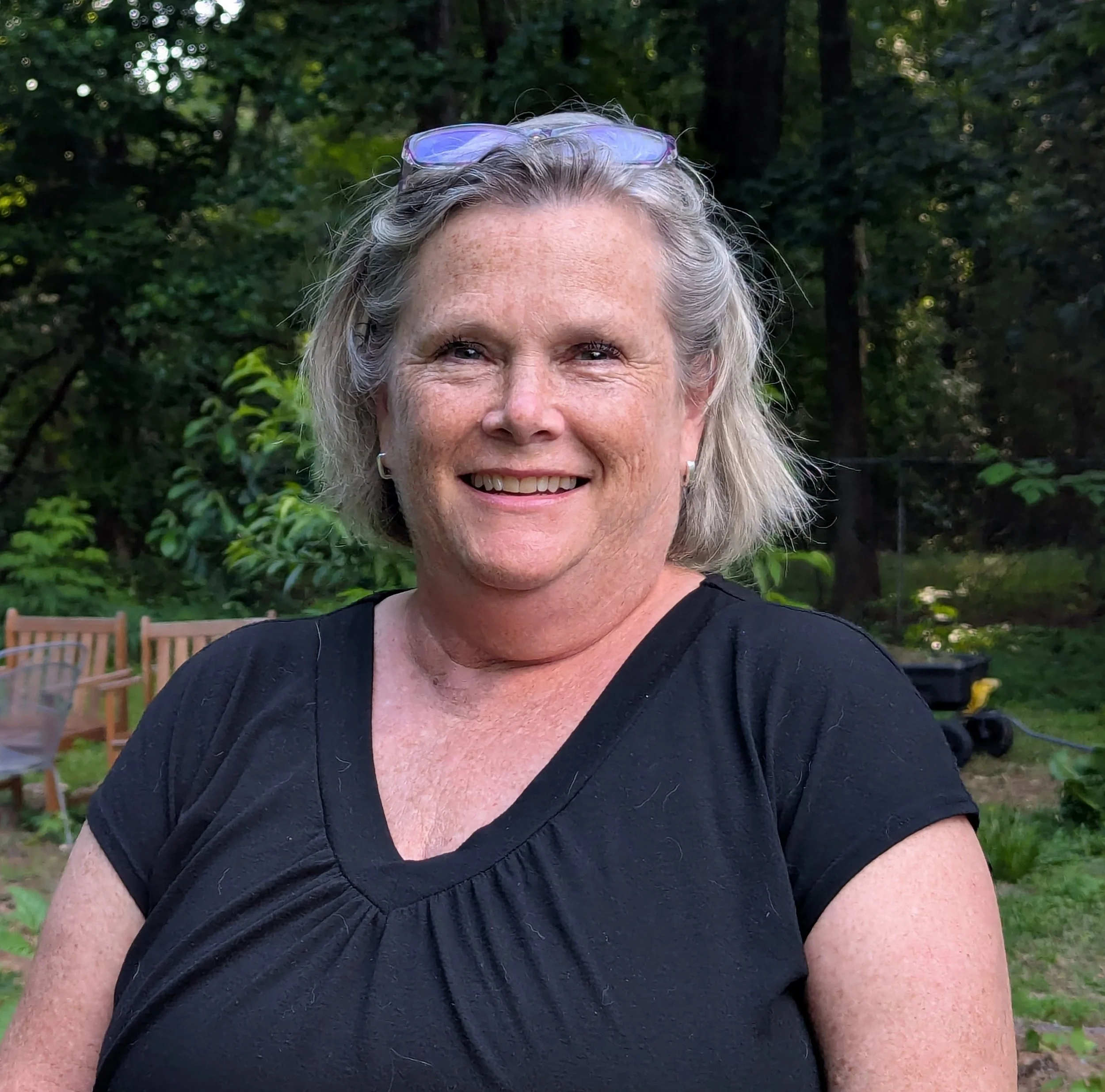 A white woman with grey-blonde hair smiles warmly.