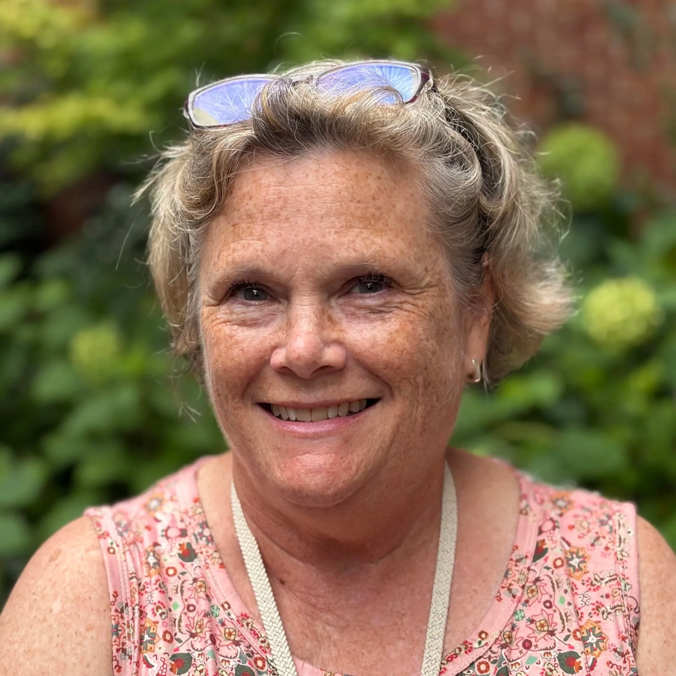 A white woman with grey-blonde hair smiles warmly. 