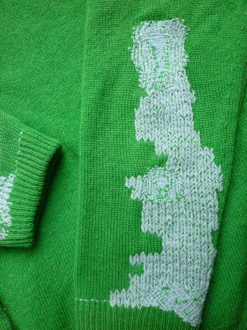 Pull vert avec une illustration blanche de la carte du Royaume-Uni.