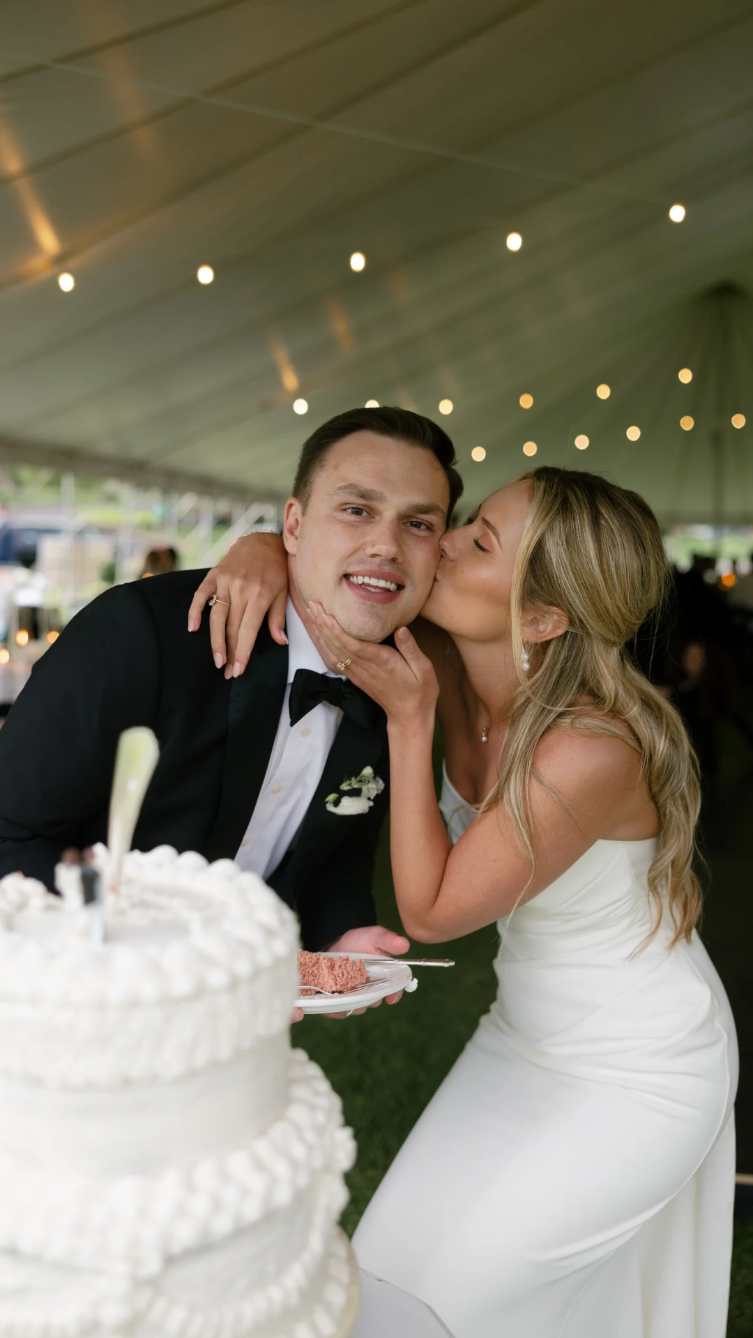 Bride and groom cut cake at tent wedding reception at the Columbia Country Club.
