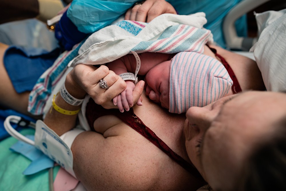 13 mom holding newborns hand for the first time.jpg