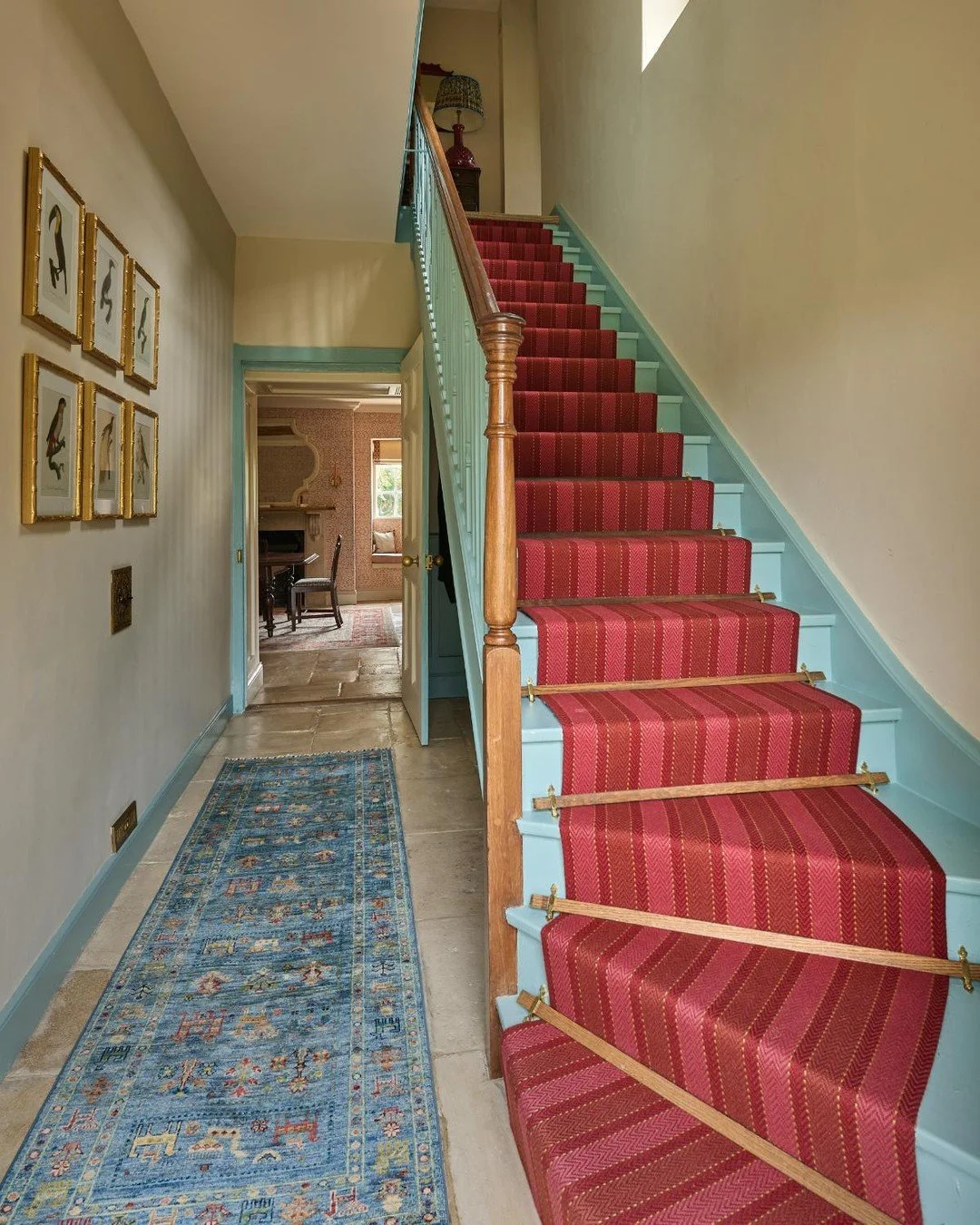 Two views of the hallway in our recent Tetbury project, featuring a fabulous stair runner from @sinclaire_till. We reused the existing wooden stair rods - and always adore the red and blue together - here we have used blue on the woodwork and picked 
