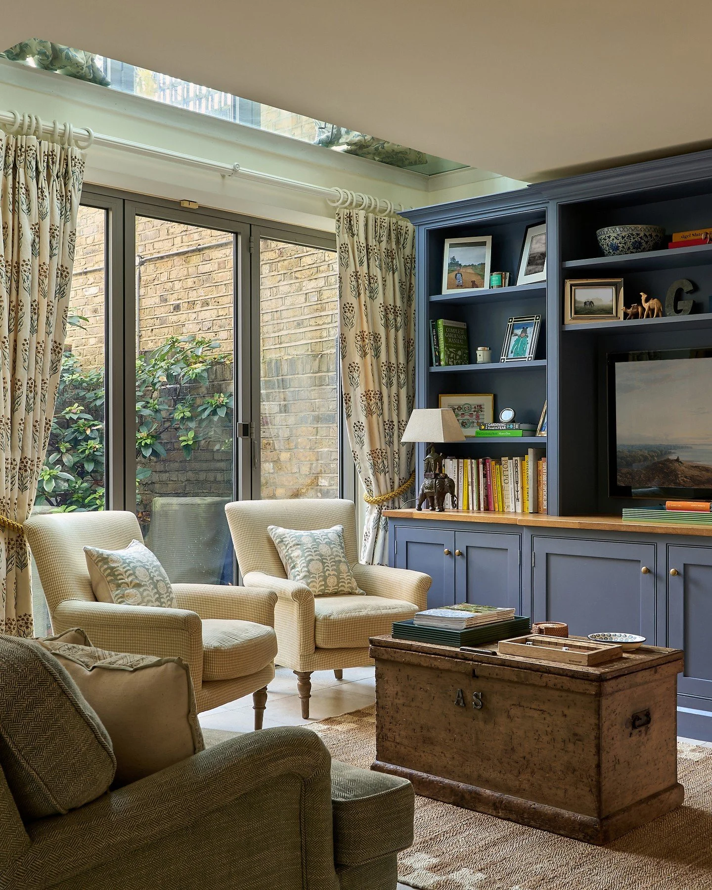 The snug / TV room in our recent Wandsworth project 🤍 Backing onto the courtyard garden, it enjoys a lovely green outlook. Custom built-in joinery neatly houses the TV, books and sentimental pieces, with generous storage tucked away below. We loved 
