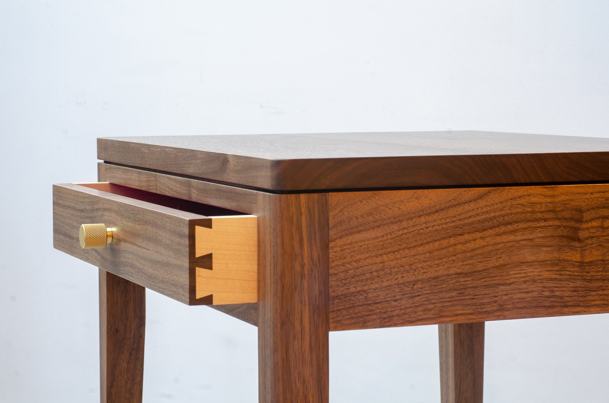 Bedside table in walnut with dovetailed sycamore drawers and brass pulls