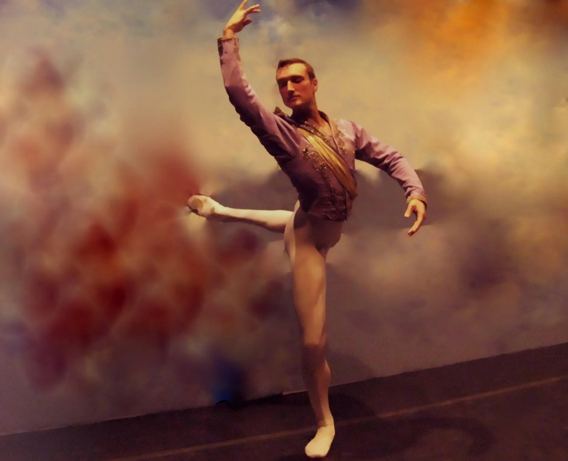 A ballet dancer in a purple costume performing an arabesque pose against a colorful, abstract background.