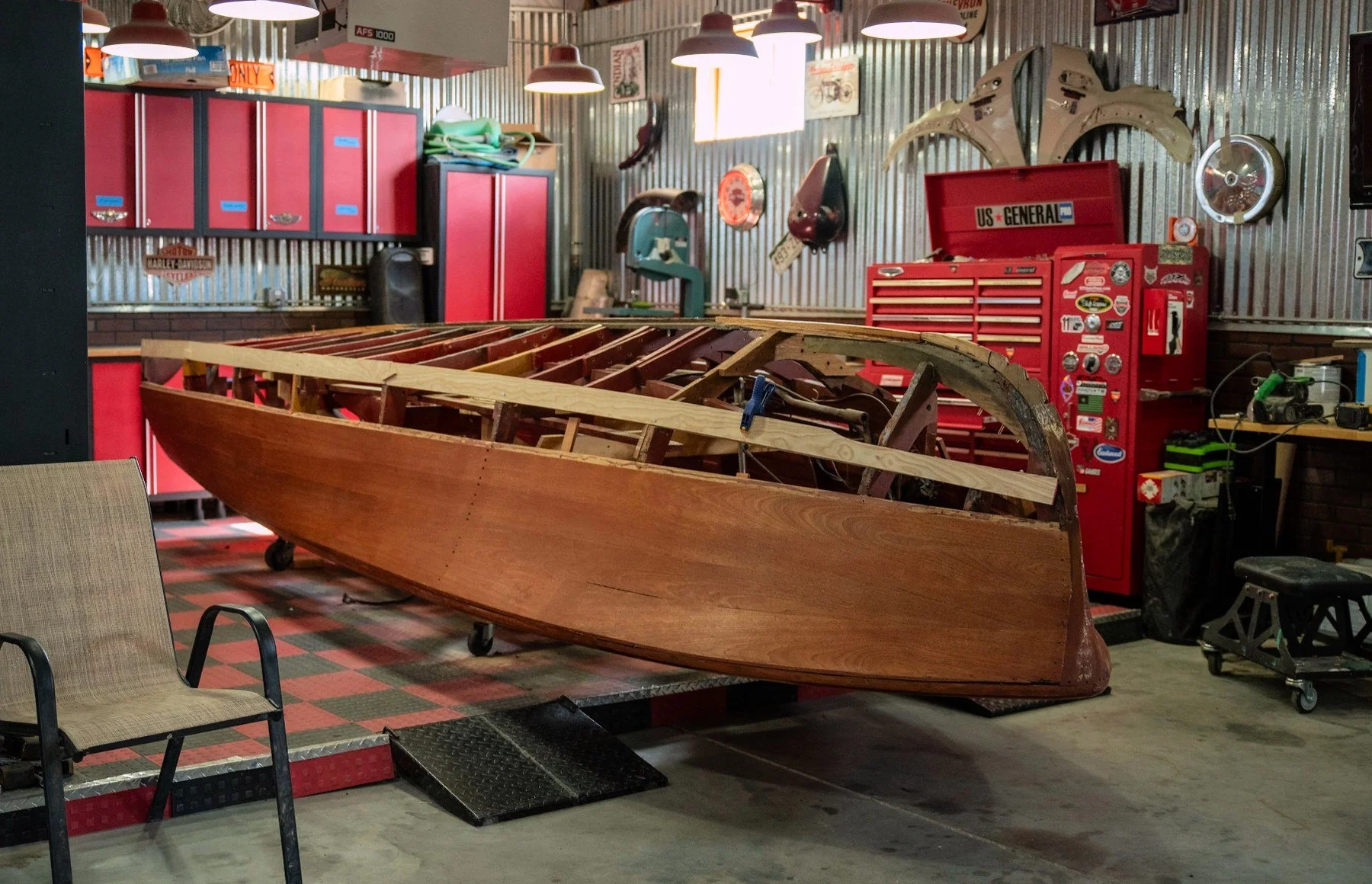 Chris-Craft wooden hull with exposed framing inside the 5280 Boatworks shop. Restoration in progress.
