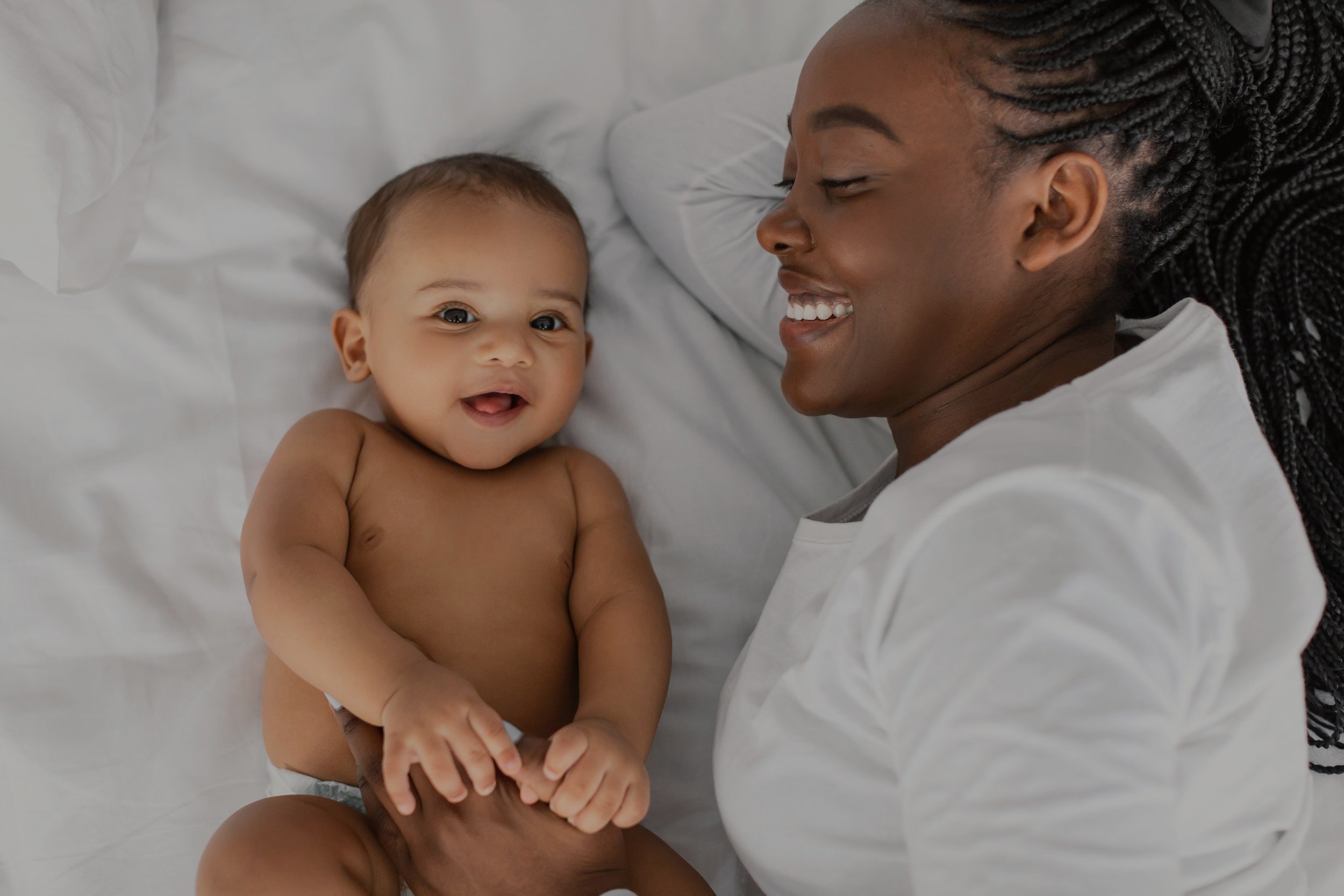 african-american-mom-lying-in-bed-with-her-laughin-2022-02-01-22-37-27-utc.jpg