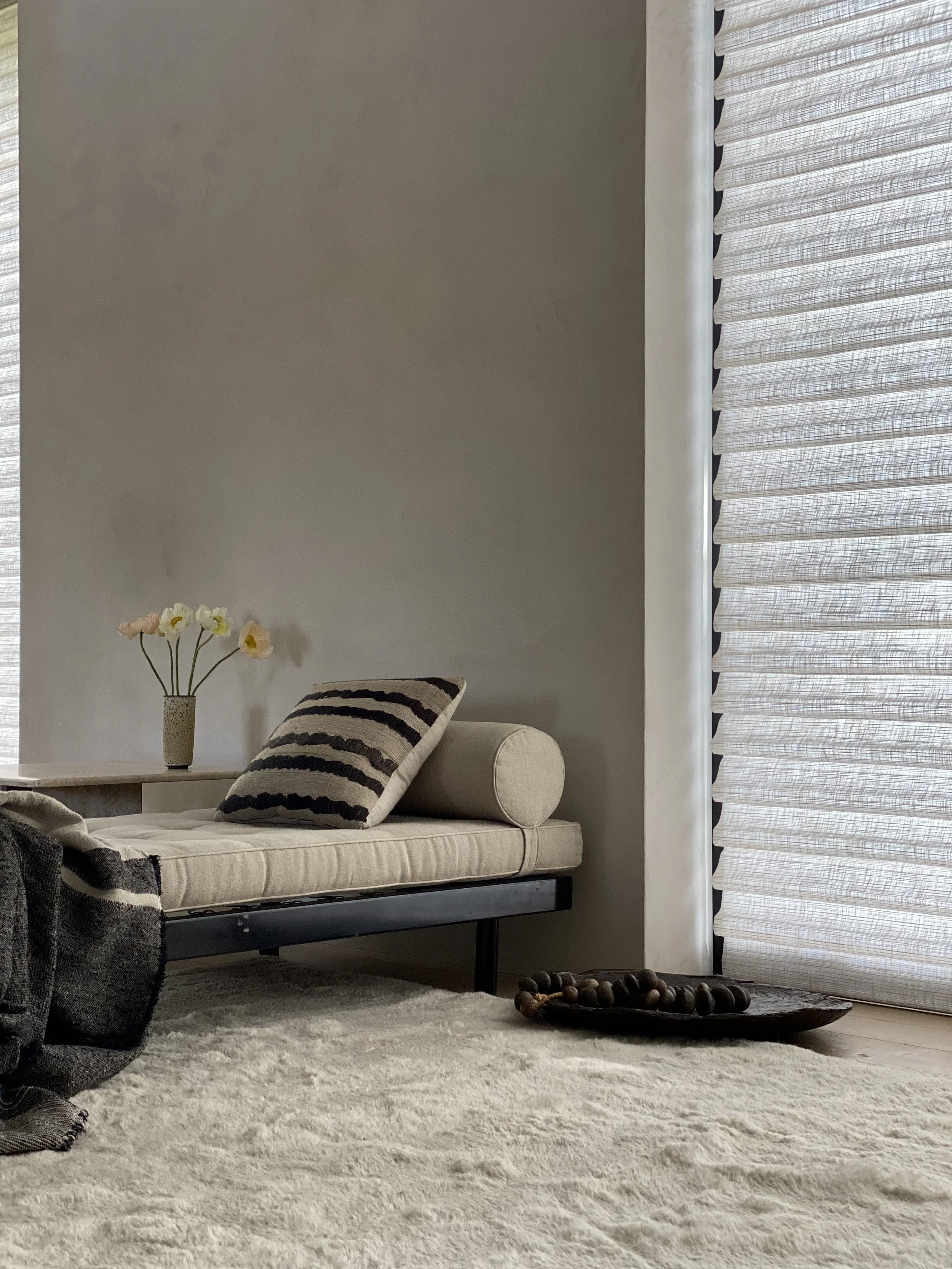 Close-up styling detail for Hunter Douglas showcasing luxury custom window treatments with a modern day bed and curated home accessories, styled by Stephen Pappas Interiors