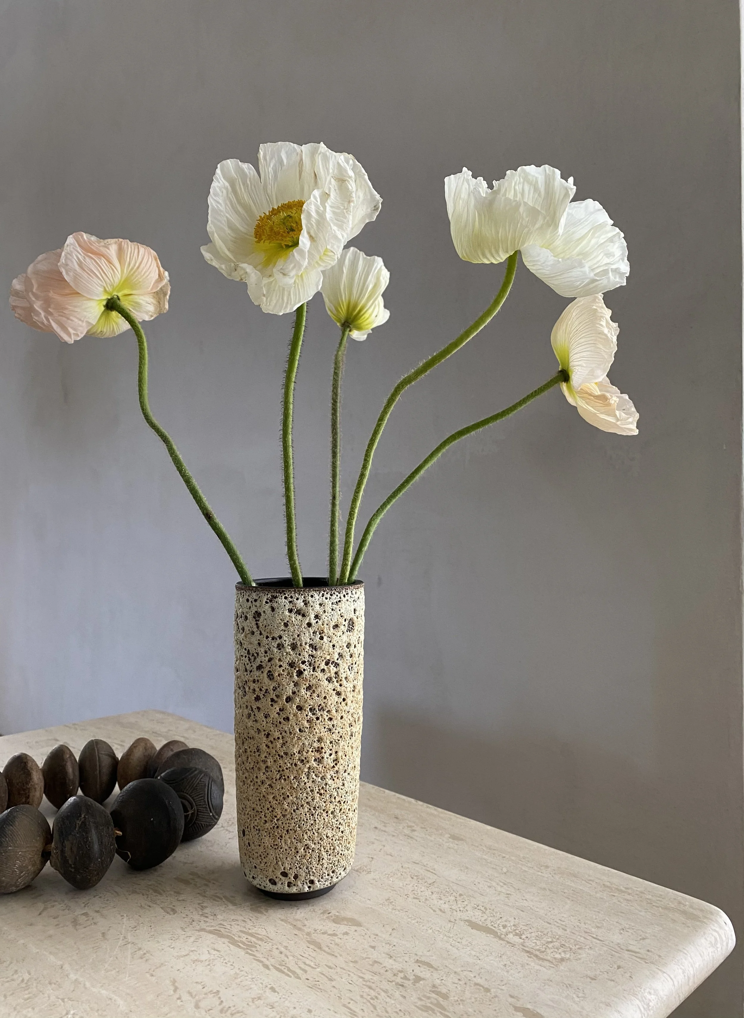 Detail of interior styling for Hunter Douglas featuring a modern vase with flowers and other luxury home accents, styled by Stephen Pappas Interiors