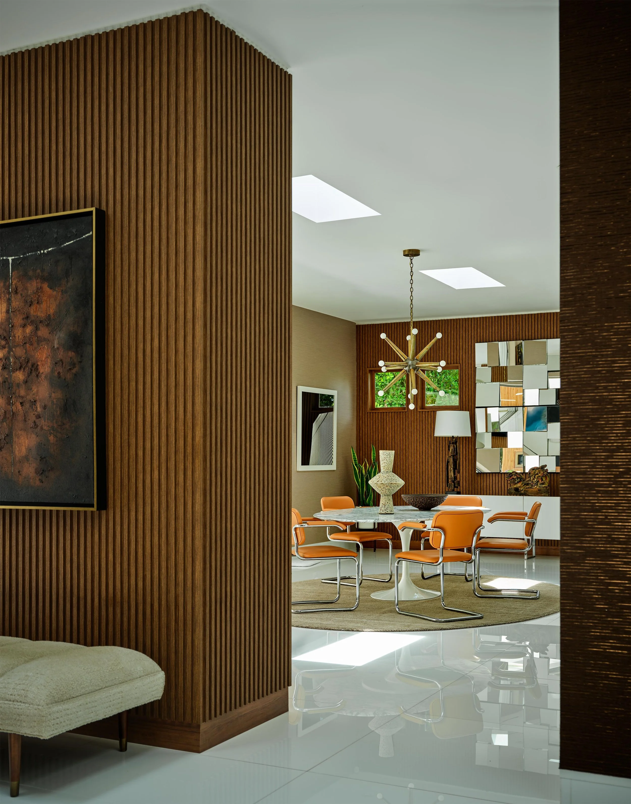 Peek-a-boo photo of dining area of Trousdale Estates area, Beverly Hills luxury home featuring modern table and seating, starburst chandelier and mid-century accents, full-service interior design by Stephen Pappas Interiors, Los Angeles