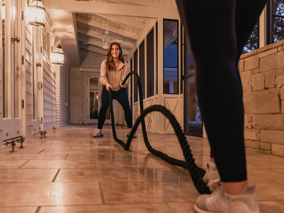 Women completing a battle rope workout during a personalized in-home fitness session designed to improve postpartum strength, stamina, and confidence.