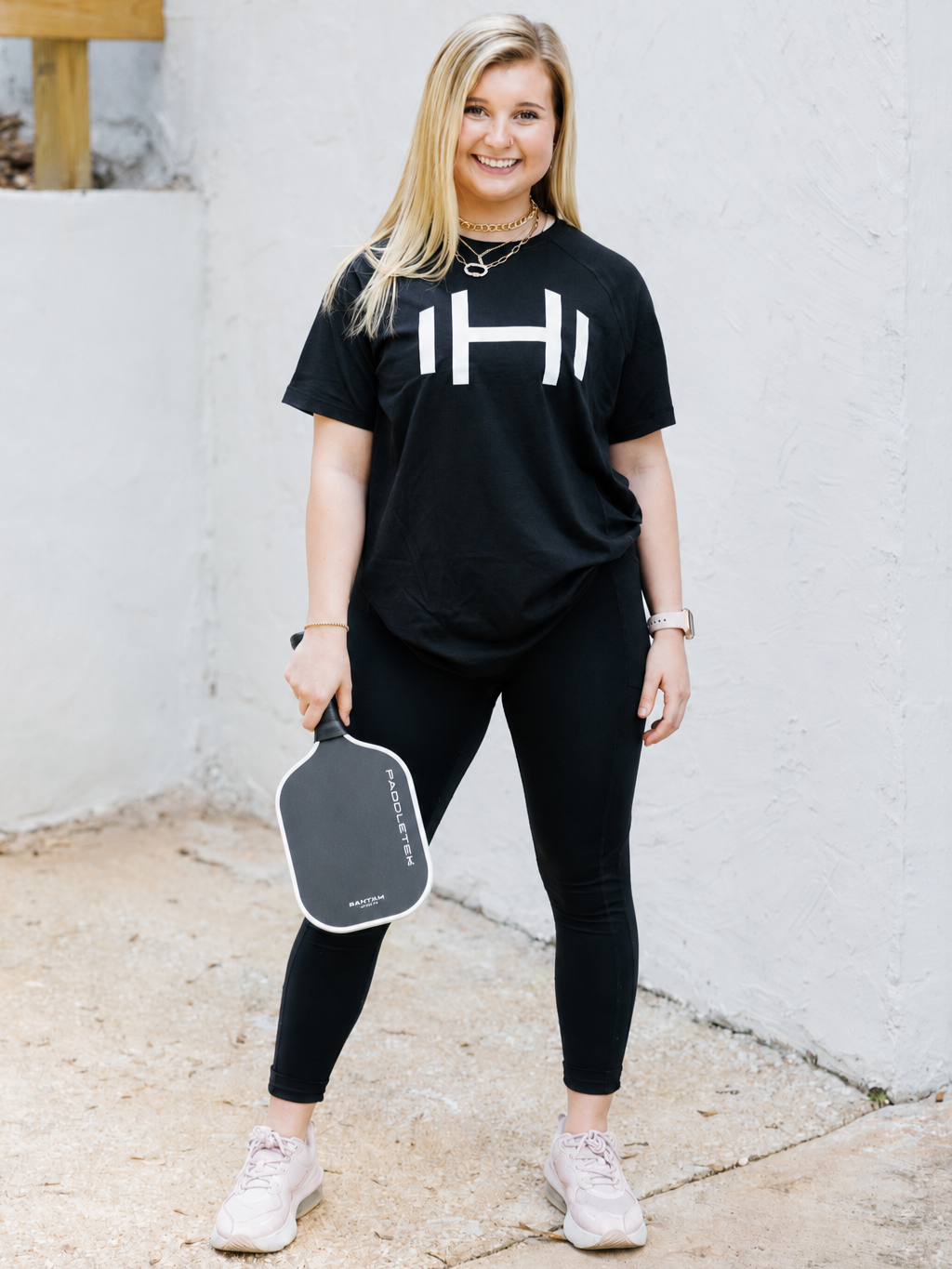 HOMEFIT trainer holding a pickleball paddle for a pickleball fitness and injury-prevention program.