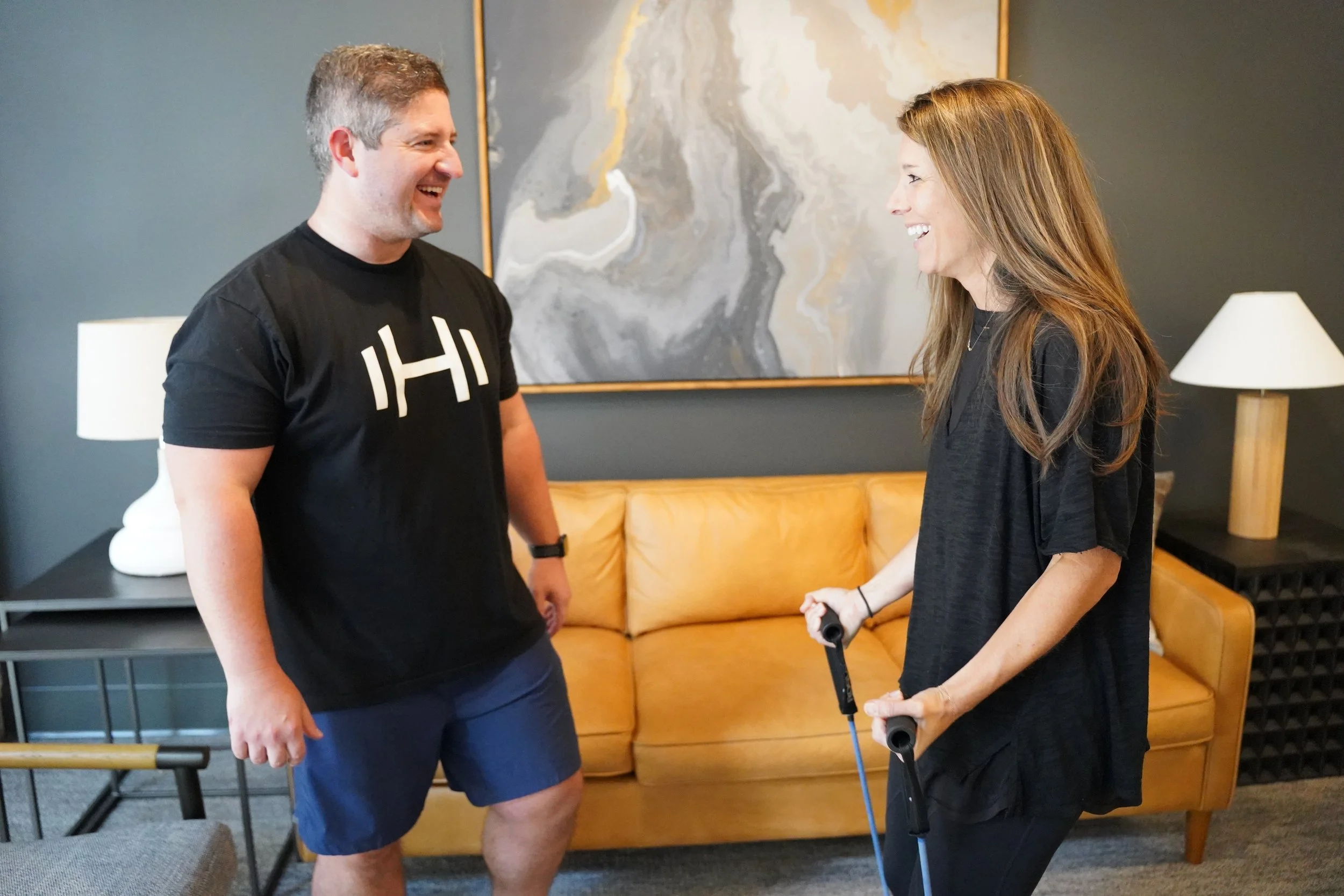 HOMEFIT in-home personal trainer guiding a client through resistance band exercises during a personalized fitness program, offering convenient one-on-one strength training, mobility improvement, and functional fitness coaching at home.