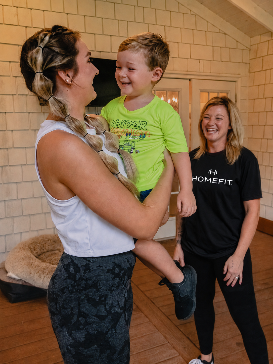 HOMEFIT personal trainer greeting a mother and young child before an in-home personal training session, showcasing family-friendly fitness coaching, customized workout programs, and convenient at-home fitness services for busy parents.