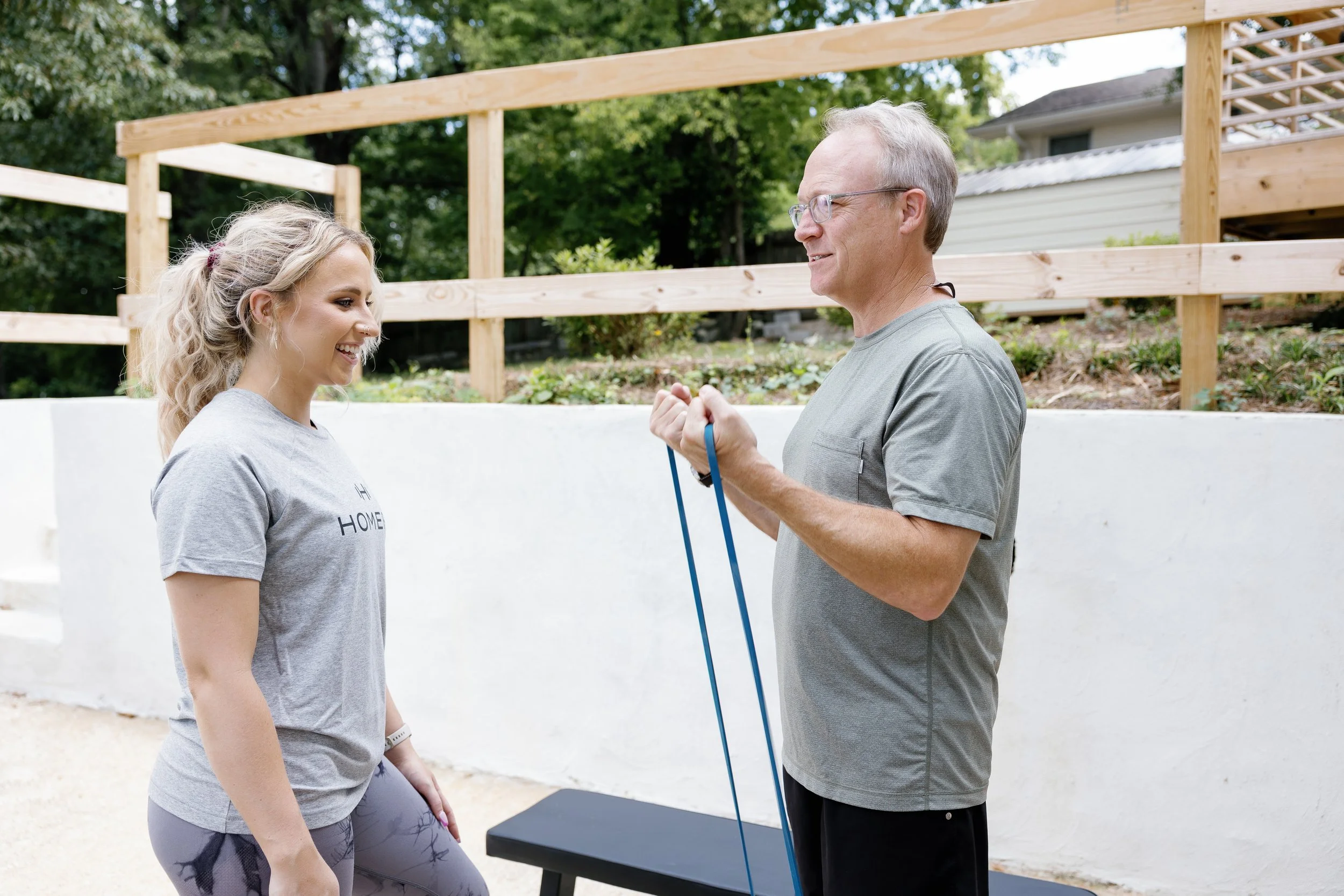 HOMEFIT personal trainer coaching a client through resistance band strength training during an at-home personal training session.