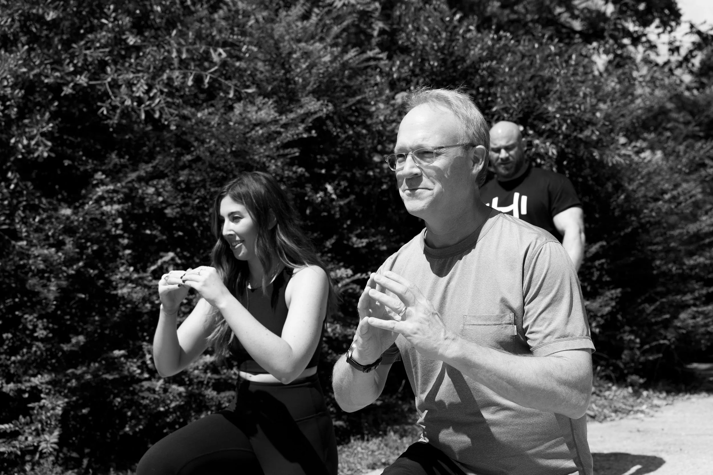HOMEFIT personal trainer guiding an older adult through an outdoor functional fitness workout, supporting strength training, balance, mobility, and healthy aging.