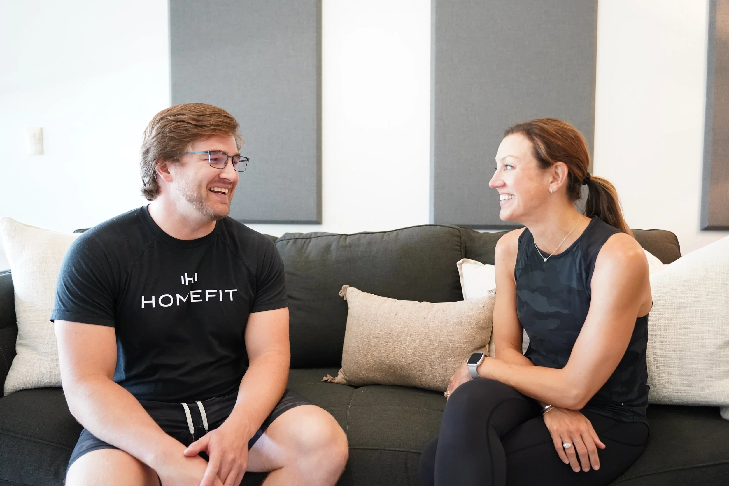 HOMEFIT personal trainer talking with a client at home about her personalized fitness plan and training goals.