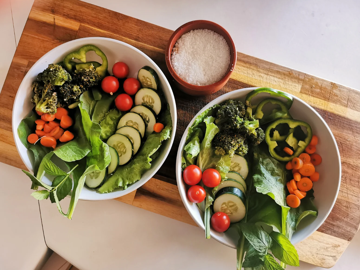 Two bowls of fresh vegetables, including spinach, broccoli, cucumbers, carrots, and cherry tomatoes, showcasing balanced nutrition, healthy eating habits, and meal preparation as part of the 75 Soft fitness and wellness challenge.
