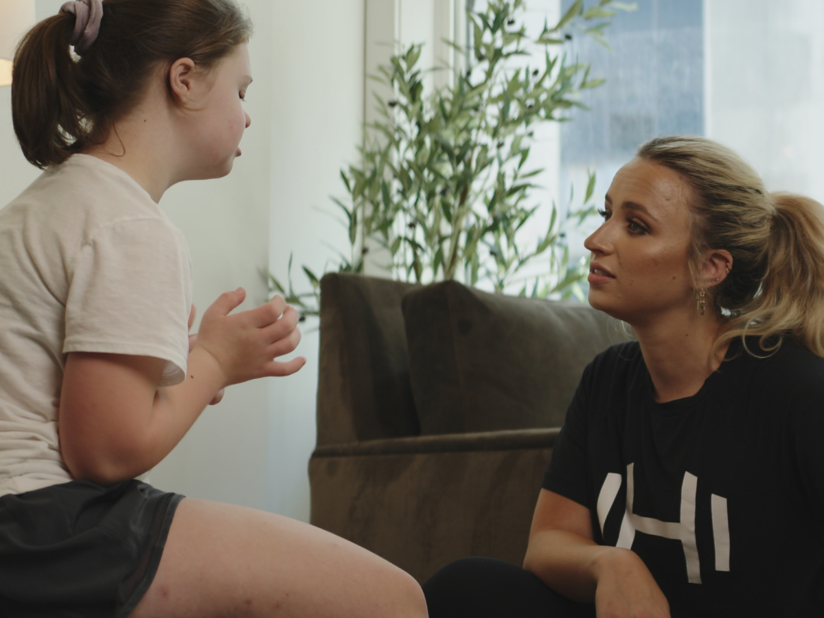 HOMEFIT personal trainer talking with a young client during an at-home fitness and wellness coaching session.
