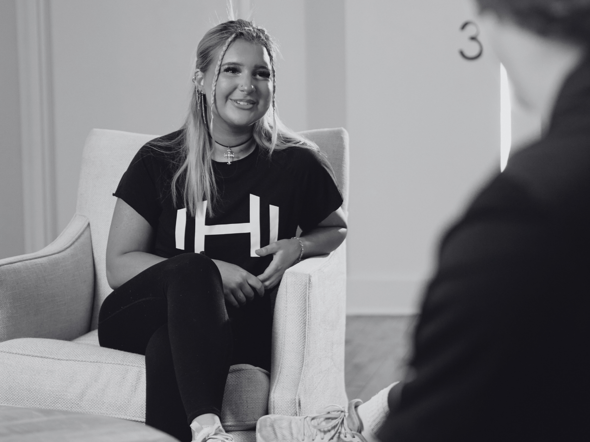 HOMEFIT coach sitting in conversation with a client in a calm setting, promoting Mental Health Awareness Month through connection, support, and overall well-being.