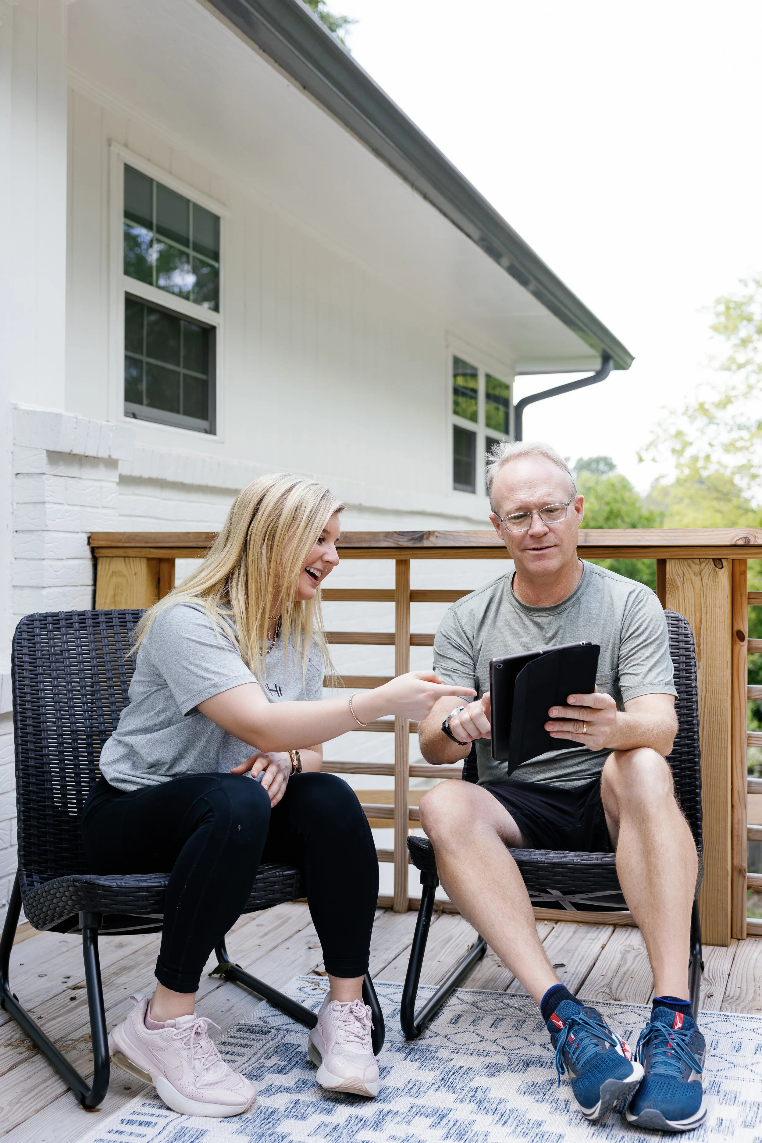 HOMEFIT personal trainer and client reviewing a ChatGPT workout plan on a tablet, showing how AI fitness tools can support personalized in-home personal training.