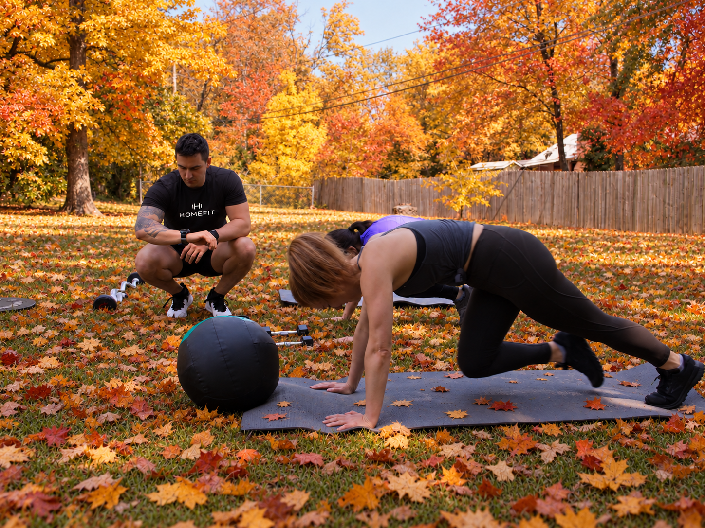 HOMEFIT personal trainer coaching clients through an outdoor fall workout with strength and conditioning exercises.