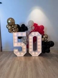 Marquee 50 with red, black, and gold balloon garland for a corporate anniversary at VEA Newport Beach