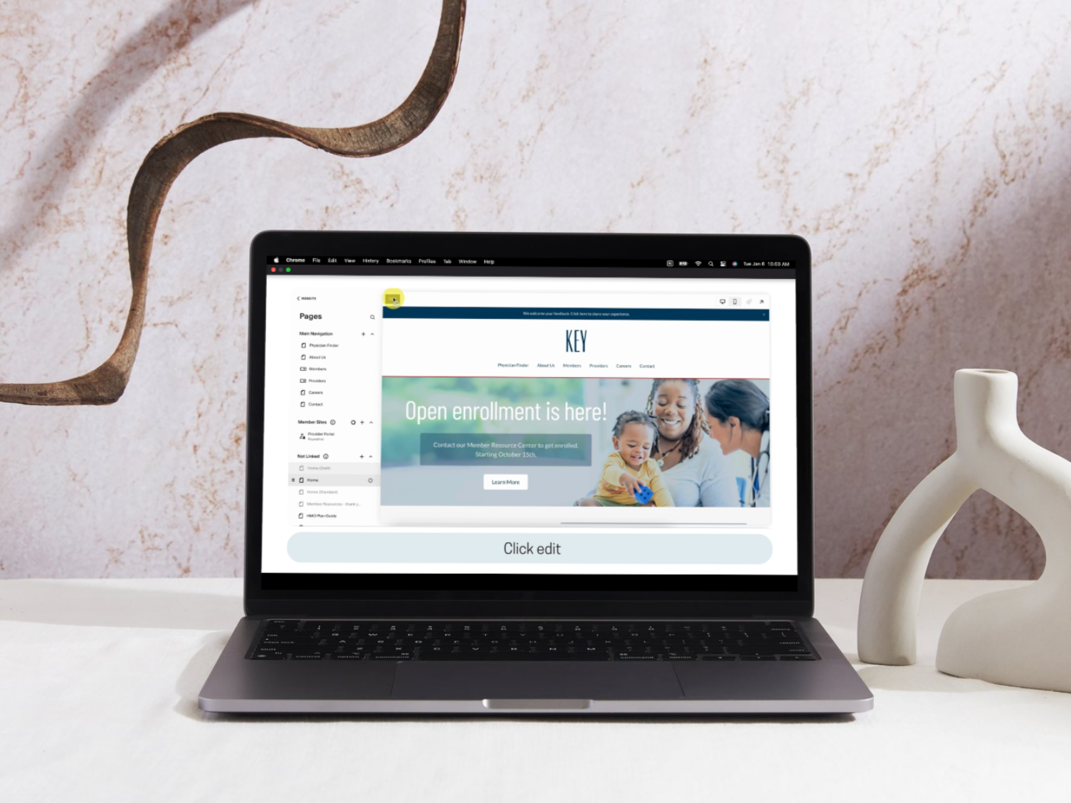 Laptop on a white desk displaying a website for enrollment with a smiling woman and child, decorative vase, and abstract wall art in the background.