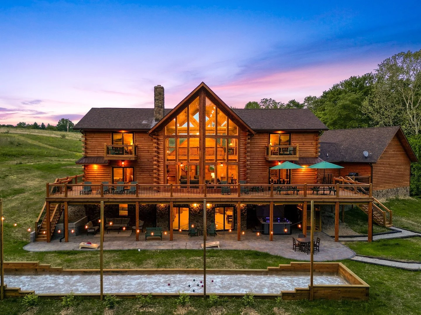 Golden Acres Lodge 🤩🤩 With its epic backyard you may not ever want to leave! The fire pit, outdoor shower, hot tub, multiple seating areas, cornhole, bocce ball court &amp; hiking trails to the stocked fishing pond will keep the whole crew entertai
