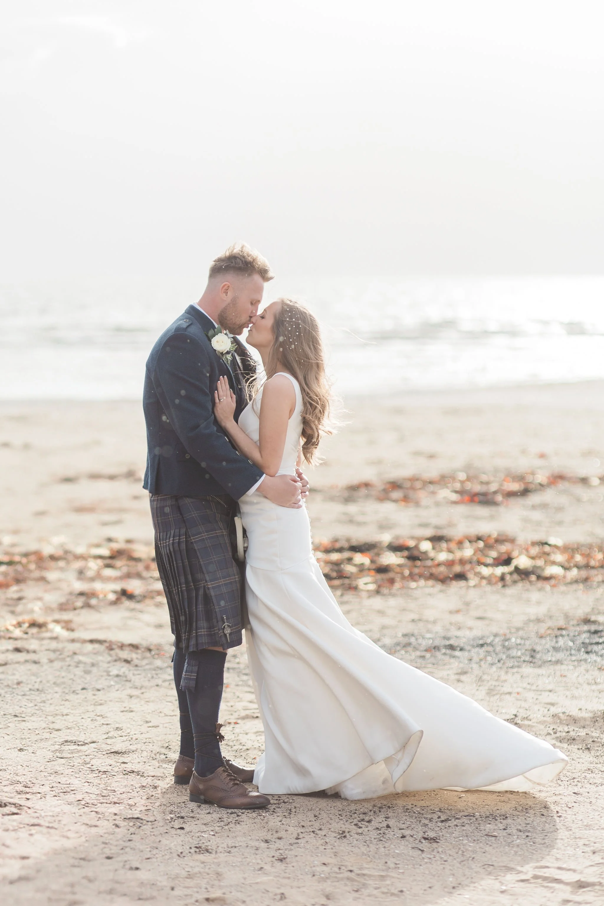Bride and groom on the beach having portraits that was scheduled into their wedding planning timeline