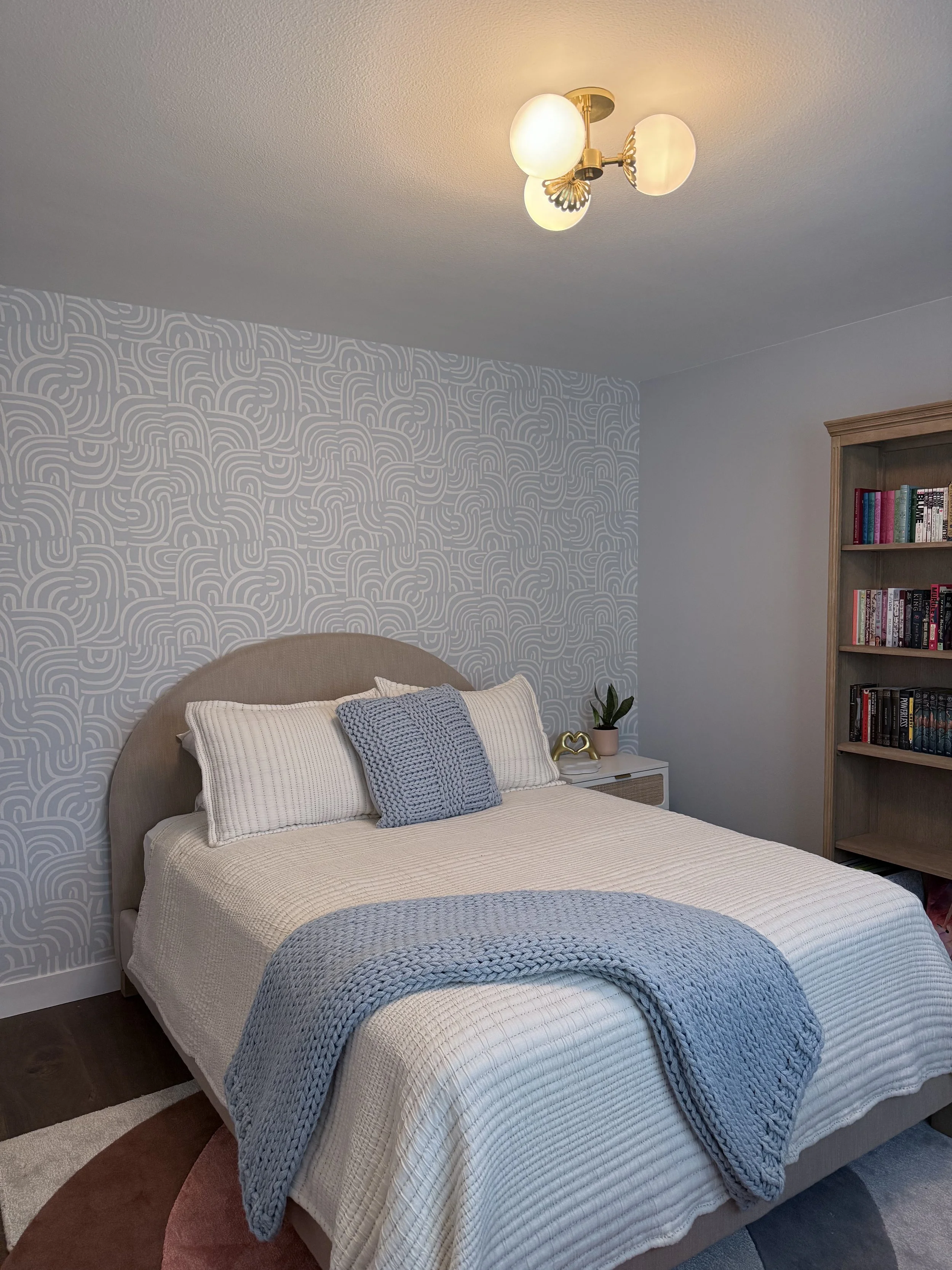 Girls' bedroom with custom window treatments and wallpaper.