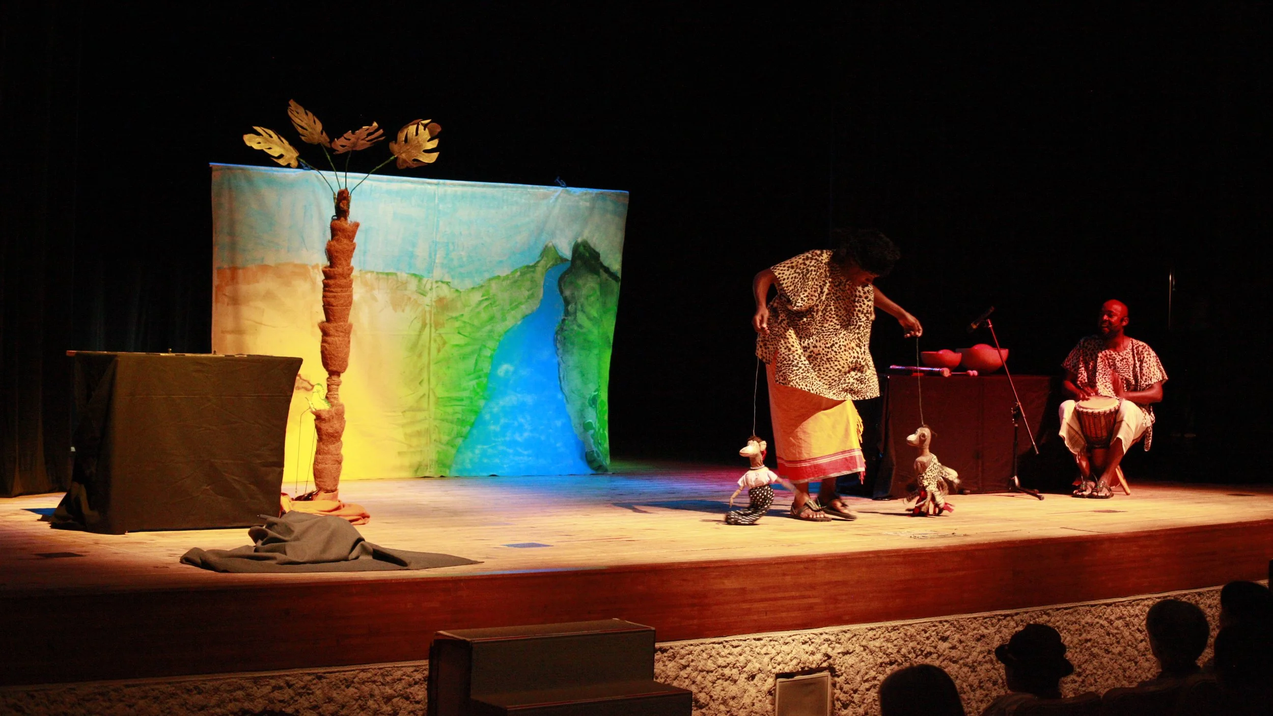 Puppets in Portland artists Fedelis Kyalo and Chrispin Mwakideu animate puppets and play djembe during a performance of Krystal Puppeteers' "Tears By The River"