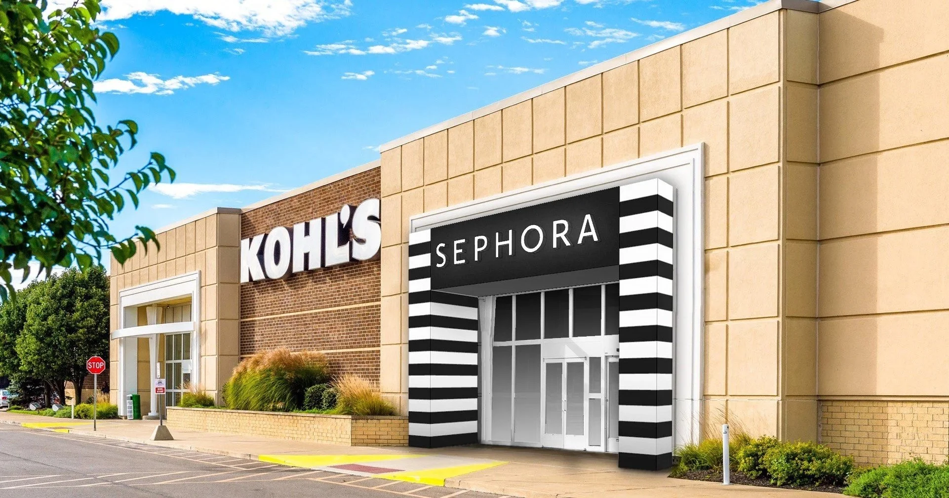 Exterior of a shopping mall with stores Kohl's and Sephora, with a mostly clear blue sky and some trees and plants outside.