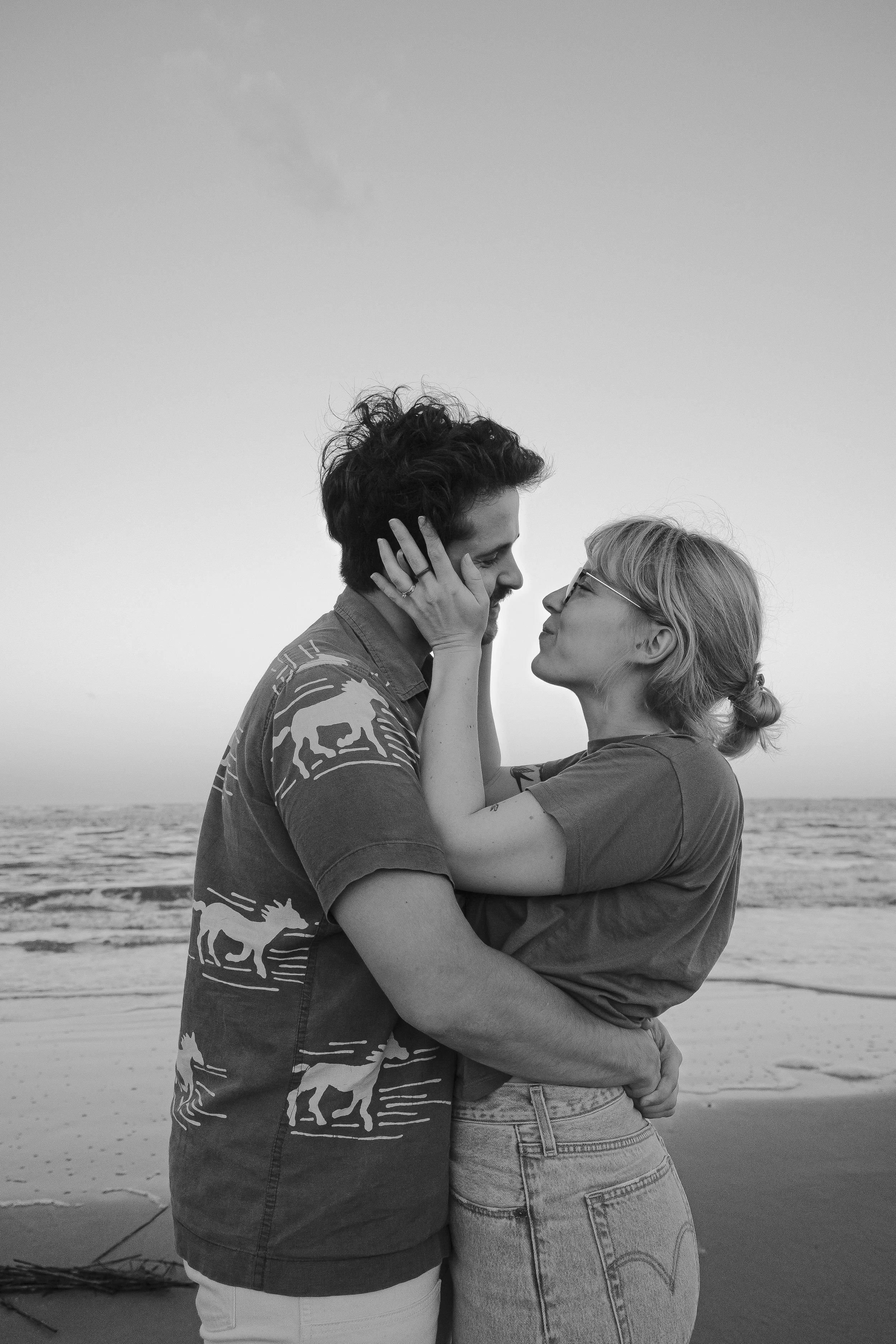 black and white photoshoot couple looking at each other hug embrace at beach