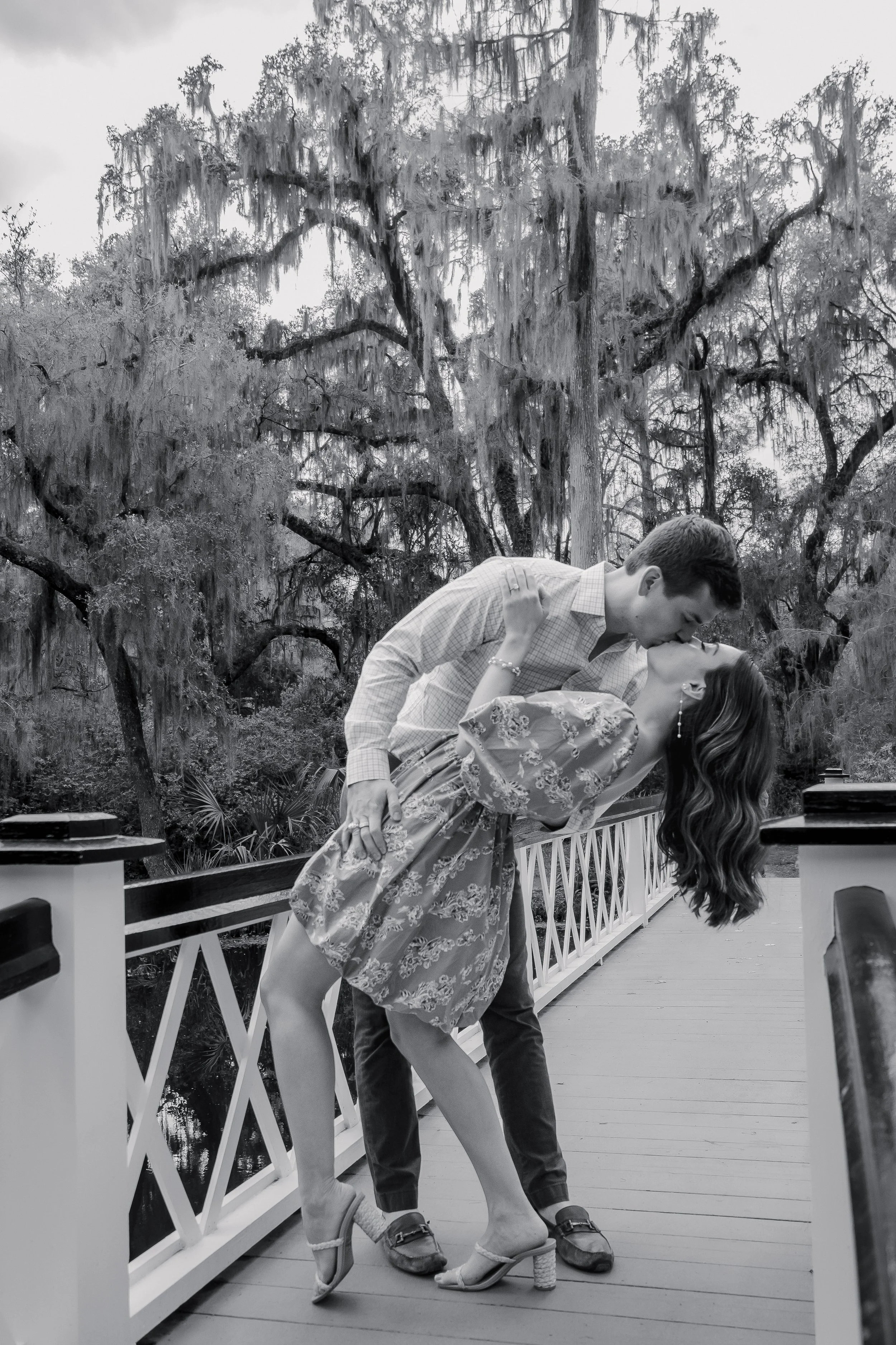 black and white engagement kissing on bridge photoshoot