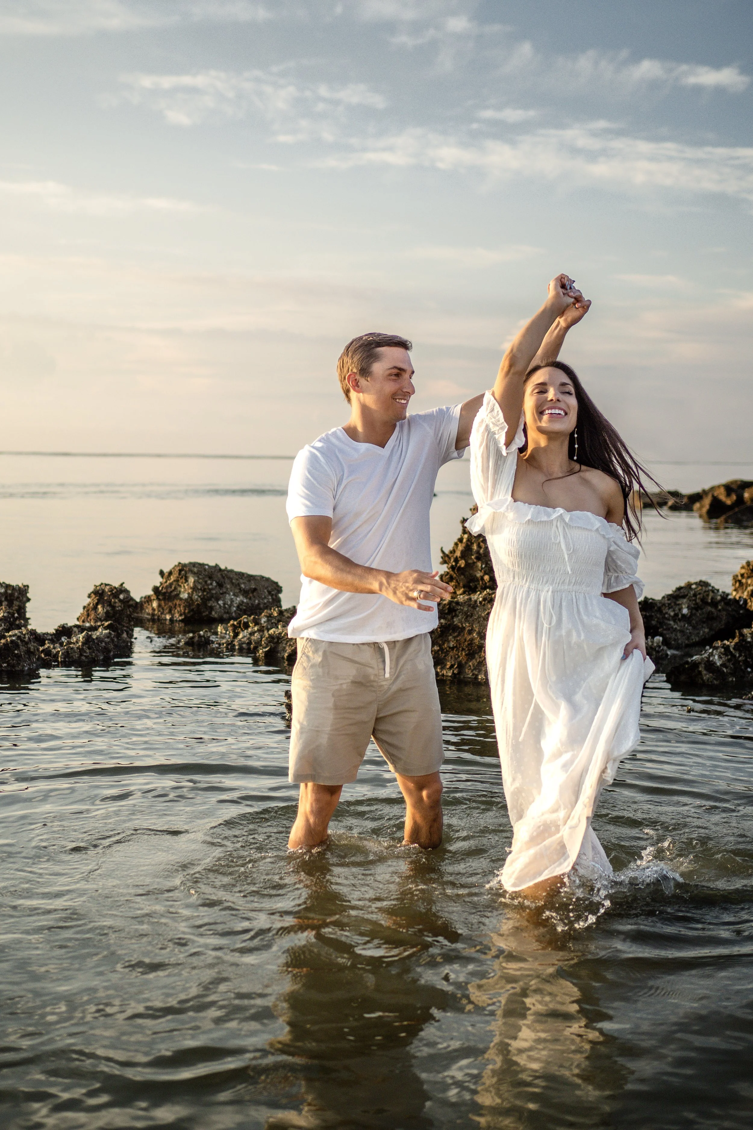 couple dancing in the ocean at sunrise photoshoot