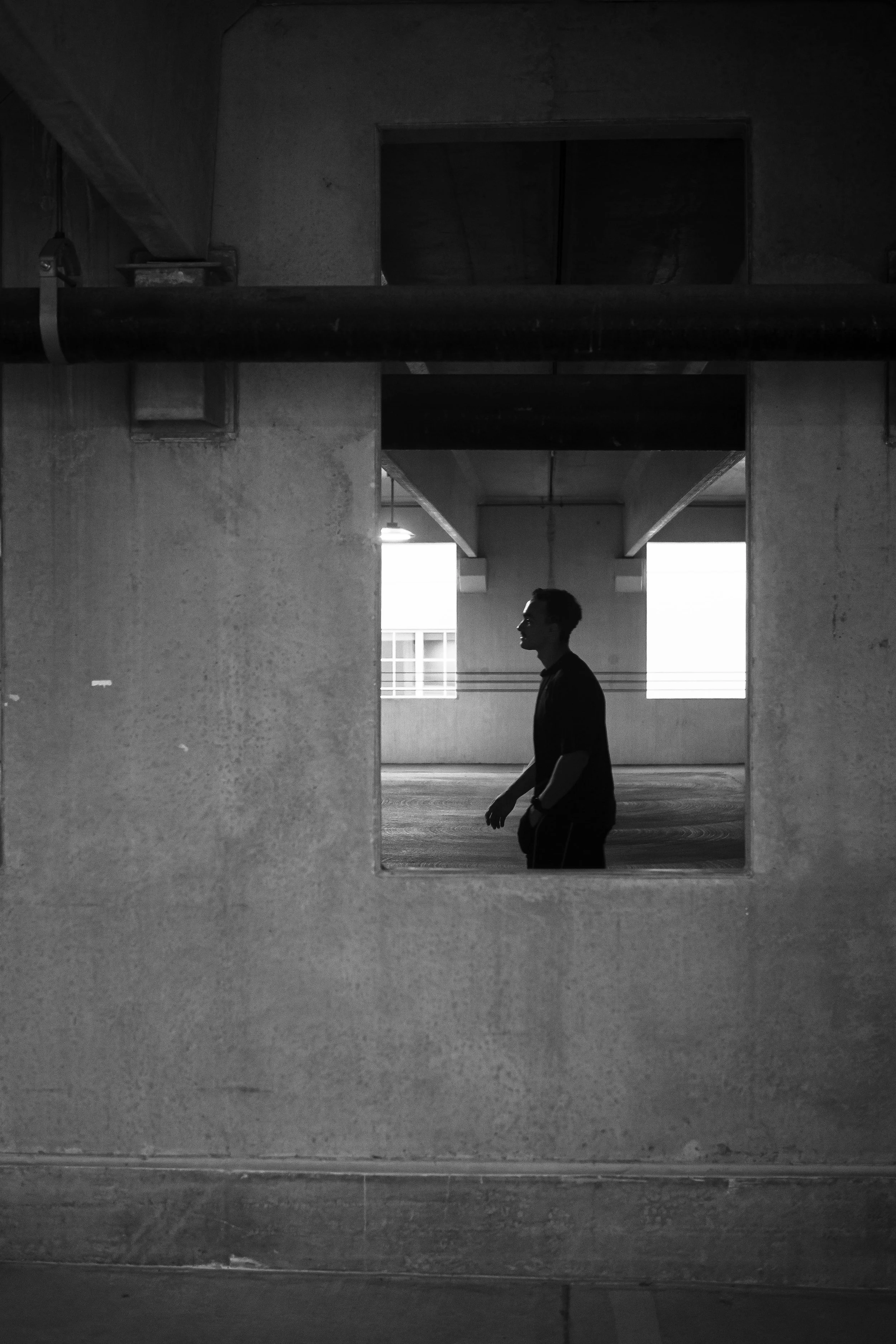 black and white photo of man in parking garage photoshoot