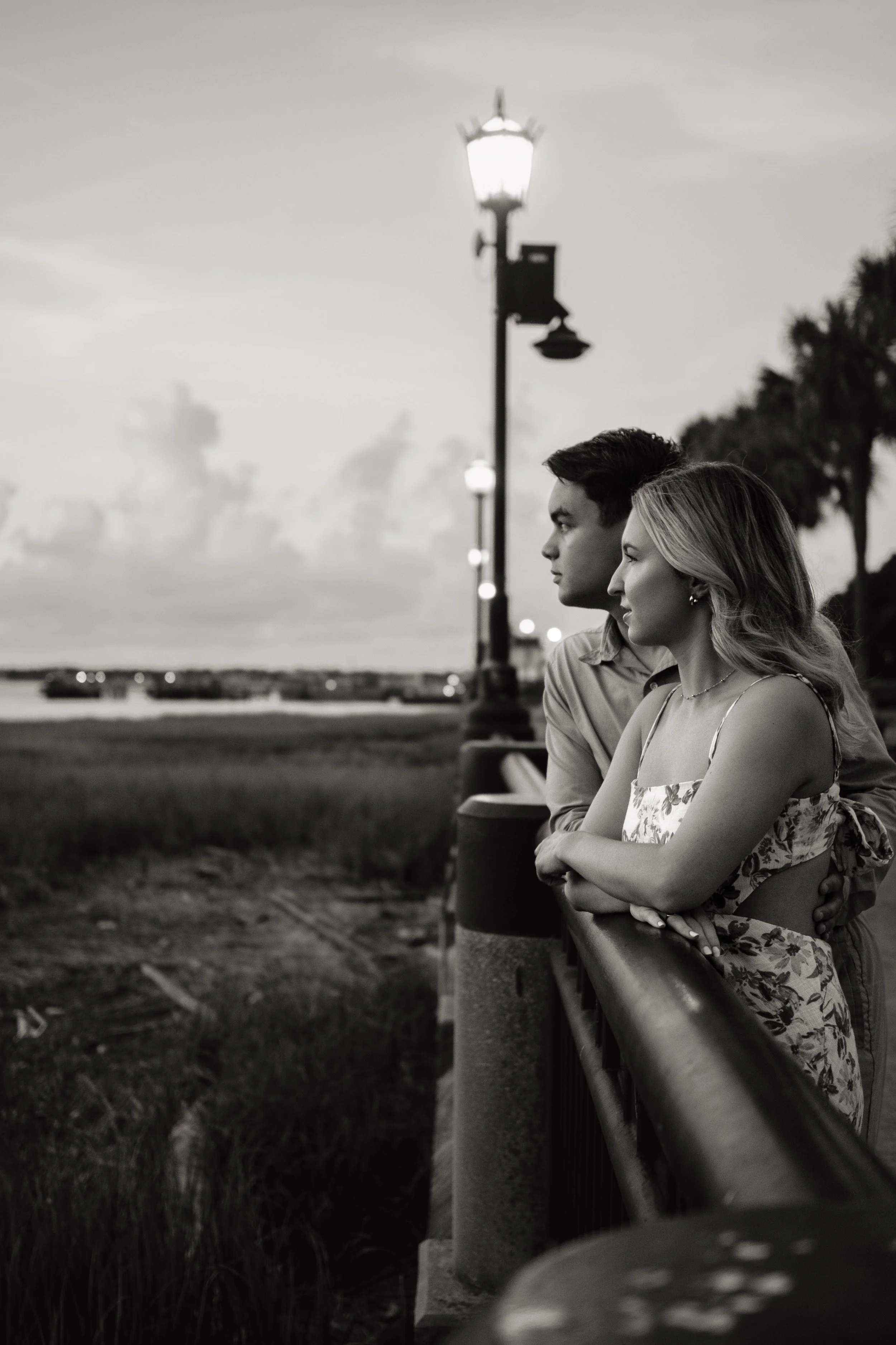black and white photoshoot couple looking over water coast 
