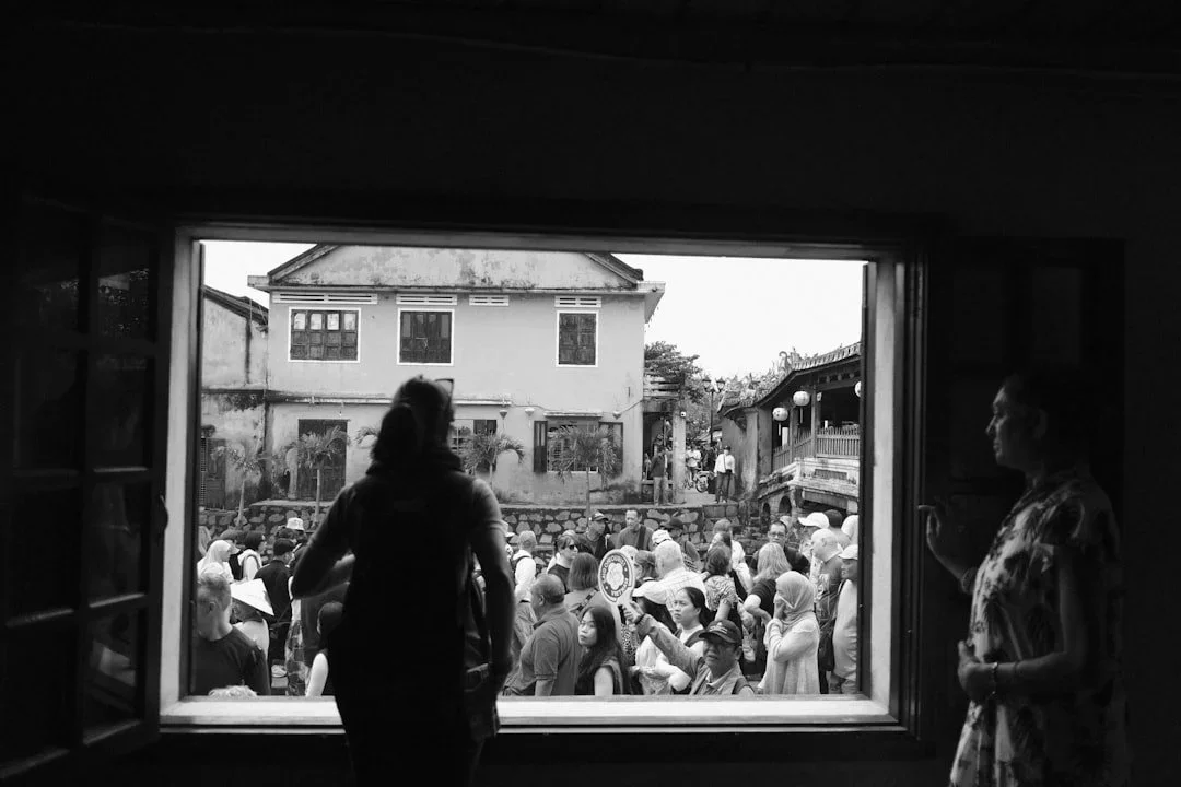 Woman looking out at others from inside, reflecting feelings of comparison and wondering if life is happening somewhere else