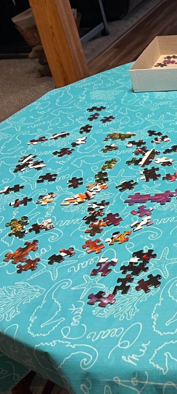 Puzzle pieces scattered on a turquoise tablecloth