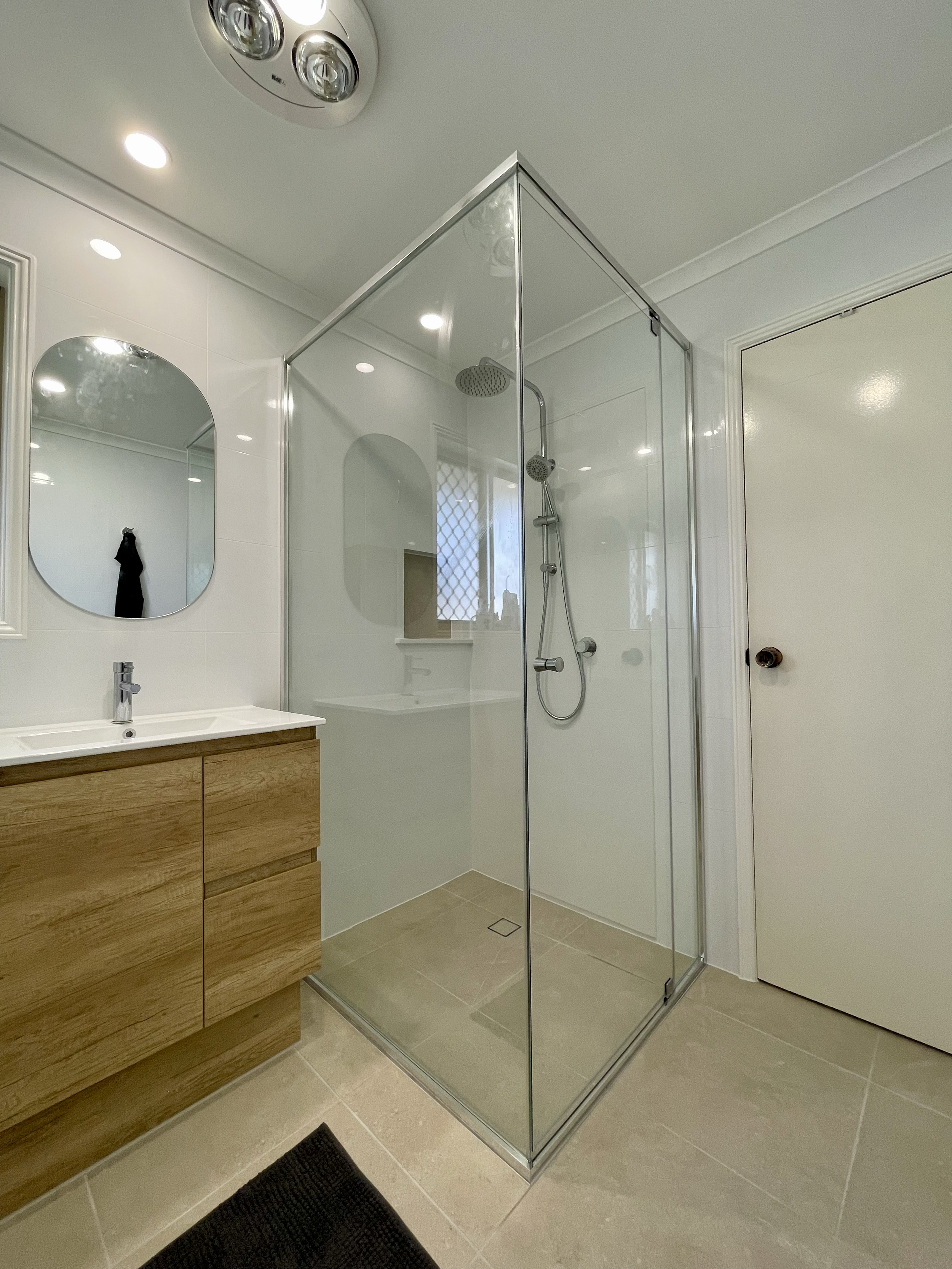Bathroom renovation Rochedale South, Logan area, Brisbane Southside. Shower and modern vanity with round mirror, grey and white times. 