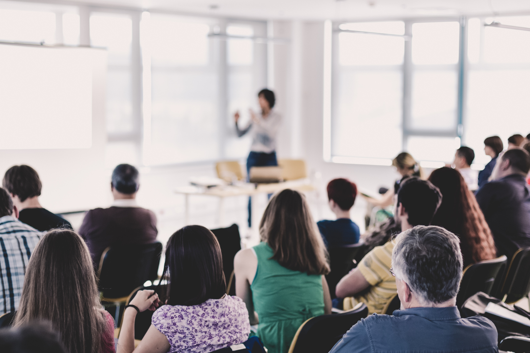 Blurred speaker in front of audience at a seminar